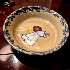 May include: A handmade wooden sign with the text "Welcome" in a playful font. The sign is painted white with a distressed finish, and features a small, decorative heart. Dimensions are approximately 12 inches wide and 6 inches tall.