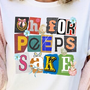May include: White t-shirt with a colorful graphic that reads "Oh for Peeps Sake." The design features pastel colors, Easter eggs, and floral accents. The shirt is a casual, everyday wear item.