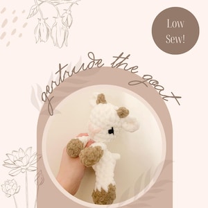 Op de afbeelding: Een gehaakt wit en bruin geitje, vastgehouden in een hand, tegen een lichtroze achtergrond. De tekst "Gertrude the goat" is cursief geschreven. De afbeelding bevat ook de tekst "Low Sew!" en "Crochet pattern by The Love Liv Collection".