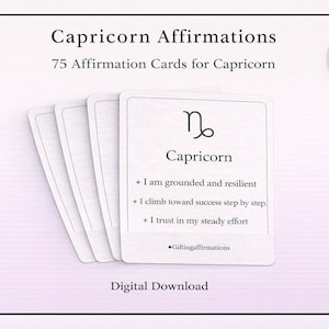 May include: White affirmation cards for Capricorn with the text "Capricorn Affirmations" and "75 Affirmation Cards for Capricorn." The cards feature the Capricorn symbol and affirmations. A circular badge reads "75 CARDS."