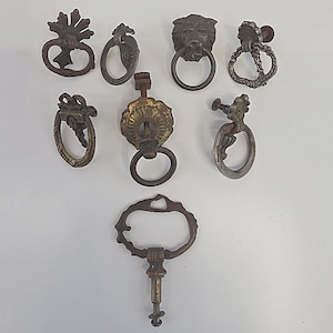 Könnte beinhalten: Eine weiße Keramik-Tasse mit schwarzem Henkel und dem Text "But First, Coffee" in schwarzer, handschriftlicher Schrift. Die Tasse steht auf einer weißen Oberfläche.