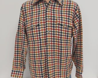 May include: A long-sleeved plaid shirt with a button-down collar. The shirt is a cream color with red, blue, and green plaid.