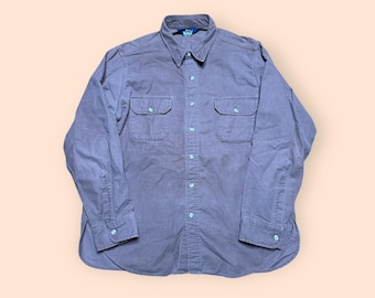 May include: A long-sleeved, light gray button-down shirt with two chest pockets and a blue label on the collar.