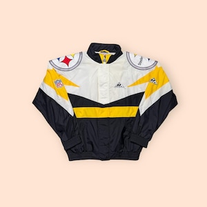 May include: A vintage black, white, and yellow Apex jacket with the Pittsburgh Steelers logo on the shoulders. The jacket features a full zip, a stand-up collar, and the NFL logo. The design includes yellow and black chevron stripes.