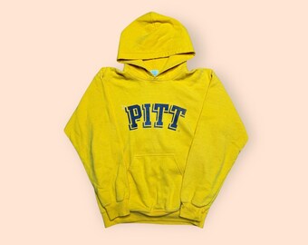 May include: Mustard yellow hoodie with the word "PITT" in navy blue block letters across the chest. The hoodie has a drawstring hood and a kangaroo pocket. The fabric appears to be a soft, comfortable material.