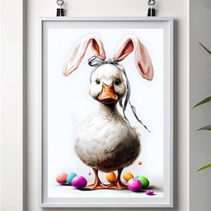 May include: A white duck wearing pink bunny ears with a grey ribbon around its head. The duck is standing on a white background with colourful Easter eggs scattered around it.