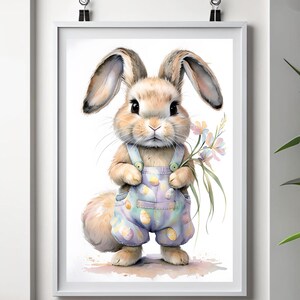 Puede incluir: Una pintura de acuarela de un conejo marrón que lleva un mono azul con un estampado de huevos pastel. El conejo sostiene un ramo de flores moradas y blancas. El fondo es blanco.