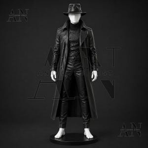 K&ouml;nnte beinhalten: Ein schwarzer Ledertrenchcoat &uuml;ber einer schwarzen zweireihigen Weste, einem schwarzen Rollkragenpullover und einer schwarzen Lederhose. Das Outfit umfasst einen schwarzen Fedora-Hut. Der Text ANTIQUES NEST ist im Hintergrund zu sehen.