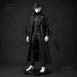 K&ouml;nnte beinhalten: Ein schwarzer Ledertrenchcoat &uuml;ber einer zweireihigen Weste, einem Rollkragenpullover und passender Hose auf einer wei&szlig;en Schaufensterpuppe. Das Set enth&auml;lt einen schwarzen Fedora-Hut. Der Text "ANTIQUES NEST" ist in den Ecken und mittig zu sehen.