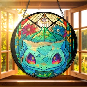 Puede incluir: Vidriera redonda con diseño de Bulbasaur. La obra de arte presenta una paleta de colores vibrantes con tonos de verde, azul, rojo y morado. Bulbasaur tiene ojos grandes y coloridos y está rodeado de patrones florales y geométricos.