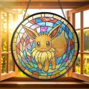 May include: A round stained glass window featuring the Pokémon Eevee. The artwork uses a variety of colors, including orange, yellow, blue, and purple. The window is framed in black and hangs from a chain.