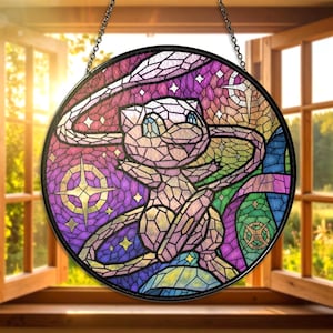 May include: A round stained glass window featuring a pink cartoon character with blue eyes, set against a backdrop of purple, green, and blue geometric shapes. The window is framed in black and hangs from a chain.