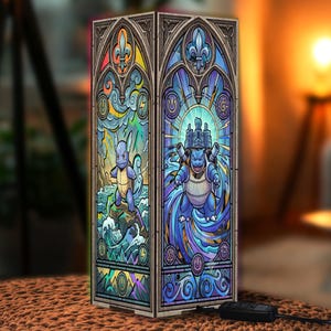 May include: A rectangular lamp featuring two panels with stained glass style illustrations of blue creatures. The left panel shows a creature on a rock amidst waves and lightning. The right panel depicts a larger creature with cannons.