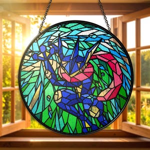 May include: Round stained glass window featuring a blue and red character design against a green and blue background. The artwork is framed in black and hangs from a chain. The window is set in front of an open window with sunlight.
