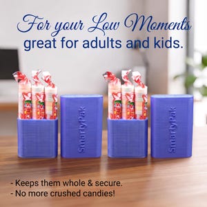 May include: Two blue rectangular SmartyPak holders, each containing three rolls of Smarties candy. The text "For your Low Moments great for adults and kids." appears at the top, and "- Keeps them whole & secure. - No more crushed candies!" at the bottom.