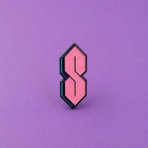 May include: A geometric enamel pin shaped like the classic universal S symbol, featuring a bright pink centre fill with dark metallic edges that create a three-dimensional effect. The design consists of fourteen segments forming a sharp, angular S shape.