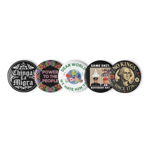 Op de afbeelding: Een verzameling van vijf ronde buttons met verschillende ontwerpen en teksten. De buttons tonen zinnen als "Chinga La Migra", "Power to the People" en "No Kings Since 1776". Andere buttons tonen afbeeldingen en tekst, waaronder een wereldbol en politieke figuren.