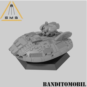 May include: A gray, futuristic-looking vehicle with a rotating turret on top. The vehicle has a rounded, aerodynamic shape and is sitting on a gray base. The text "Banditomobil" is printed below the vehicle.