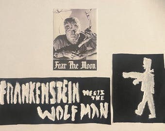 Puede incluir: Tres parches en blanco y negro con temas de películas de terror. Un parche presenta una imagen en blanco y negro de un hombre lobo con el texto "Fear The Moon". Otro parche dice "Frankenstein Meets The Wolfman". El tercer parche es una silueta blanca de un monstruo.