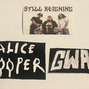Könnte beinhalten: Drei Aufnäher mit Bandlogos und einem Foto. Der obere Aufnäher trägt die Aufschrift "Still Reigning" über einem Bandfoto. Darunter befinden sich zwei schwarze Aufnäher mit weißer Schrift: "ALICE COOPER" und "GWAR".