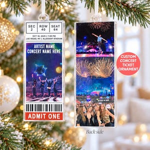 May include: A rectangular acrylic concert ticket ornament featuring a white ribbon hanger. The front displays event details, a star graphic, and a crowd scene. The back shows a performer on stage and a concert audience with fireworks.