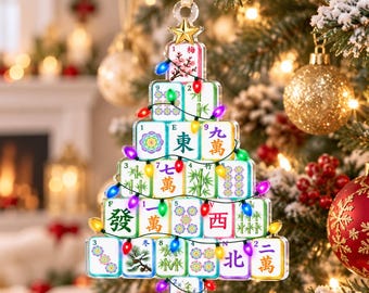 Könnte beinhalten: Ein weihnachtsbaumförmiger Anhänger aus gestapelten Mahjong-Spielsteinen mit verschiedenen Symbolen, Schriftzeichen und Blumenmotiven. Der Schmuck ist mit einer Lichterkette aus kleinen, bunten LED-Lichtern verziert und mit einem goldenen Stern gekrönt.