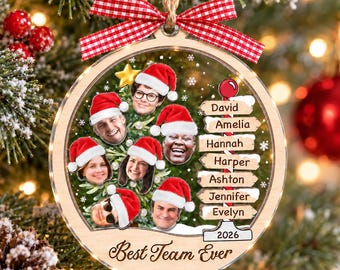 May include: A round wooden Christmas ornament featuring a red and white gingham bow, seven circular photos of people wearing Santa hats, a signpost with names David, Amelia, Hannah, Harper, Ashton, Jennifer, Evelyn, and the text Best Team Ever 2026.