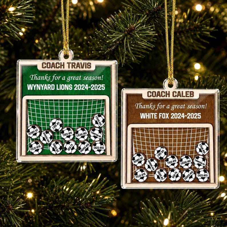 May include: Two square wooden ornaments featuring a soccer goal graphic. One has a green background with text COACH TRAVIS, Thanks for a great season! WNYARD LIONS 2024-2025. The other has a brown background with COACH CALEB, Thanks for a great season! WHITE FOX 2024-2025. Both include small soccer ball tokens with names and numbers.