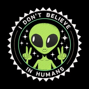 May include: Embroidered patch featuring a green alien with large black eyes and a peace sign gesture. The alien is surrounded by the text "I DON'T BELIEVE IN HUMANS" in a circular design with a white sawtooth border, set against a black background.