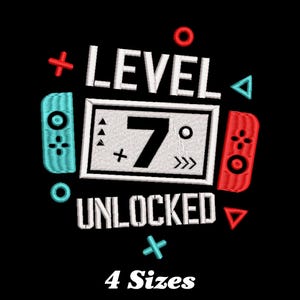 May include: Embroidered design featuring a video game controller with the text "Level 7 Unlocked" in white. The design is on a black background and includes various game symbols in red and blue.