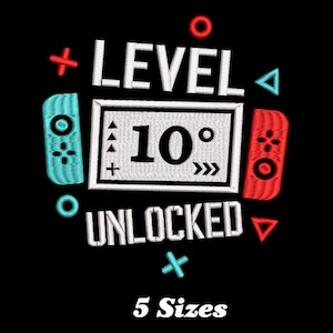 Könnte beinhalten: Gestickte Grafik mit einem Videospiel-Controller und dem Text "Level 10 Unlocked" in Weiß auf schwarzem Hintergrund. Das Design ist in 5 Größen erhältlich.