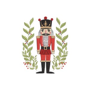 Könnte beinhalten: Gesticktes Bild eines weihnachtlichen Nussknackersoldaten in roter Uniform, schwarzen Stiefeln und einem schwarzen Hut mit goldenen Akzenten. Der Nussknacker ist von einem grünen Blätterkranz mit roten Beeren umgeben, vor weißem Hintergrund.