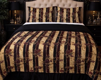 May include: A bed with a floral patterned comforter and pillow set. The comforter has vertical stripes in tan, burgundy, and black, with rose accents. The bed is made up with a black bed skirt and a black throw blanket.