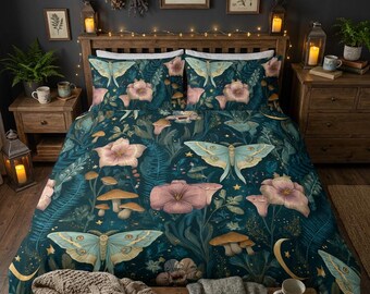 May include: A dark teal duvet cover and two matching pillowcases featuring a repeating pattern of light blue luna moths, pink flowers, brown mushrooms, green ferns, and small yellow crescent moons and stars printed across the fabric surface.