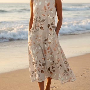 May include: A sleeveless midi dress in a light beige color featuring a repeating pattern of brown and muted green leaves. The dress has a round neckline, a relaxed fit, and includes side pockets integrated into the skirt's side seams.