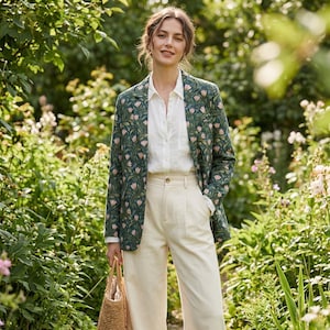 Peut inclure: Un blazer vert foncé orné d'un motif répétitif de tulipes roses et de feuilles vertes, porté sur une chemise blanche boutonnée et un pantalon crème. Le blazer présente un revers cranté et une fermeture à un seul bouton sur le devant.