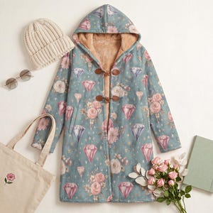 May include: A teal coat with a hood, adorned with a diamond and floral print, toggle fastenings, and a tan faux fur lining. Accessories include a beige beanie, sunglasses, a tote bag with a floral design, and a notebook.