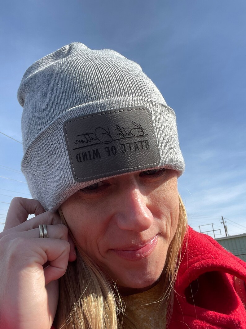 May include: Gray beanie with a brown leather patch that says "State of Mind" in black lettering.