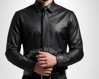Puede incluir: Una camisa de cuero negra con corbata a juego y pantalones negros. La camisa tiene mangas largas y un cuello clásico. El conjunto se completa con un cinturón negro. El texto "fashion Miles UK" es visible en la manga.