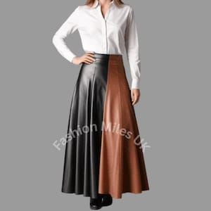 May include: A long, two-tone skirt with a black and brown color block design. The skirt is paired with a white button-down shirt. The skirt appears to be made of leather or a leather-like material.