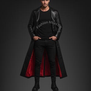 May include: A long black leather coat with a red lining. The coat is buttoned at the top and open at the bottom, showing the red lining. The coat is worn with black trousers and a black top.