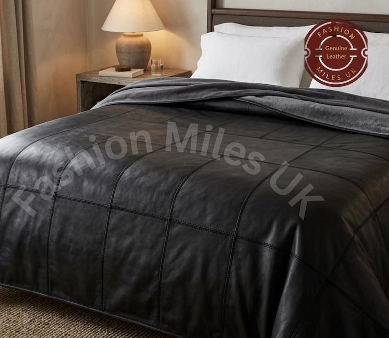 May include: A black leather bedspread featuring a grid-like patchwork design with visible stitching. The bedspread is draped over a bed with white pillows. A circular logo in the corner contains the text Fashion Miles UK Genuine Leather.
