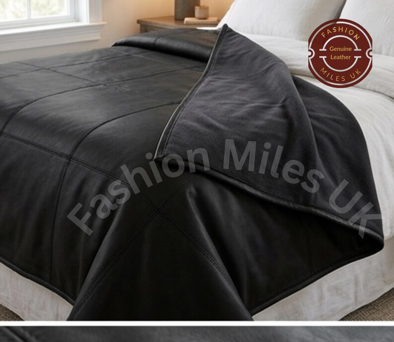 May include: A black leather bedspread featuring a grid-like stitched pattern and a smooth finish. The textile is draped over a white bed. A circular logo in the corner contains the text Fashion Miles UK and Genuine Leather.