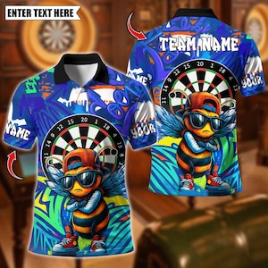 Puede incluir: Polo azul con un gráfico de diana y una abeja de dibujos animados con gafas de sol y gorra. La camisa tiene el texto "TEAM NAME" y "YOUR" en la espalda, y "NAME" en la parte delantera. La camisa tiene un cuello negro.