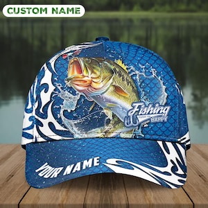 Può includere: Un cappellino da baseball blu a tema pesca. Il cappellino presenta una grande grafica di un pesce che salta con schizzi d'acqua. Il testo "Fishing makes me happy" è visualizzato sul lato. Il cappellino ha i testi "CUSTOM NAME" e "YOUR NAME".