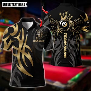 May include: A black polo shirt featuring gold and grey tribal patterns, a collar with three buttons, and an eight-ball graphic with a crown. The front displays the text "YOUR NAME" and the back features an eight-ball design with "TEAM NAME".