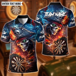 Puede incluir: Un polo de manga corta con un diseño de calavera pirata. La camisa presenta una calavera con un sombrero de pirata, un tablero de dardos y las palabras "Team Name" y "Your". El fondo es una mezcla de azul, rojo y naranja.