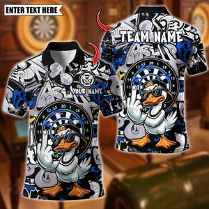 May include: A polo shirt with a black collar and a design featuring a cartoon duck wearing sunglasses and a backwards cap, giving the middle finger. The shirt has a dartboard graphic and the text "YOUR NAME" and "TEAM NAME". The background has a graffiti-style design.