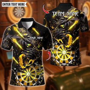 Op de afbeelding: Zwarte poloshirt met een brullende panter en dartbord ontwerp. Het shirt heeft de tekst "ENTER TEXT HERE", "YOUR NAME" en "TEAM NAME". Het ontwerp gebruikt geel en zwart.