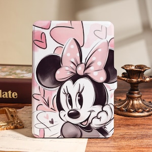 May include: A white and pink tablet case featuring Minnie Mouse with a pink polka dot bow and hearts. The design is a cartoon illustration with a black outline and pink accents. The case is rectangular and has a cutout for the camera.